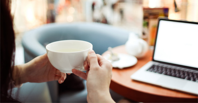 コーヒーを片手に仕事する人